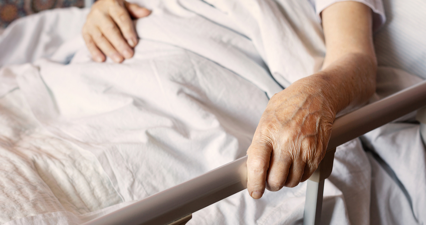 Hand of elderly woman in bed